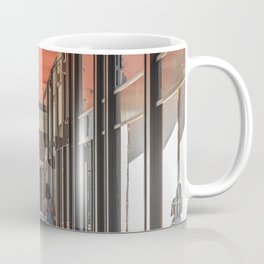 A woman from behind pushes a stroller under the arcades of the city Coffee Mug